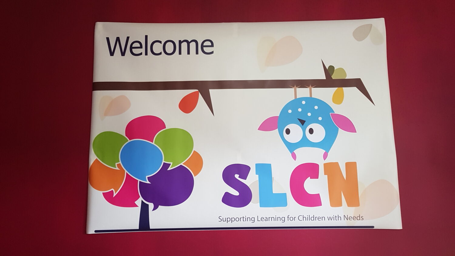 Banner with "welcome" text, an illustration of a colorful tree, and an upside-down character. Text below reads "slcn supporting learning for children with needs. " discover our therapy room rental options to create the perfect space for nurturing and growth.