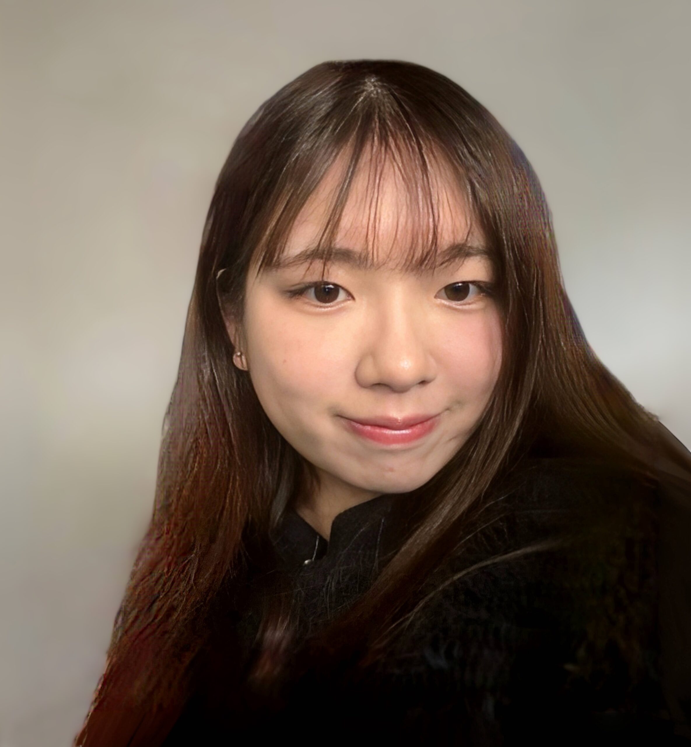 Claire Yao, with long hair and fringe, wearing a black top, looks at the camera with a slight smile against a neutral background.
