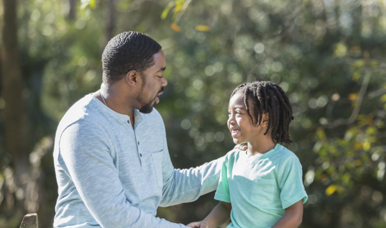 An african american father and his son in a park.