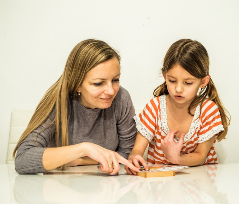A young girl and her mother are playing a game of tic-tac-toe.