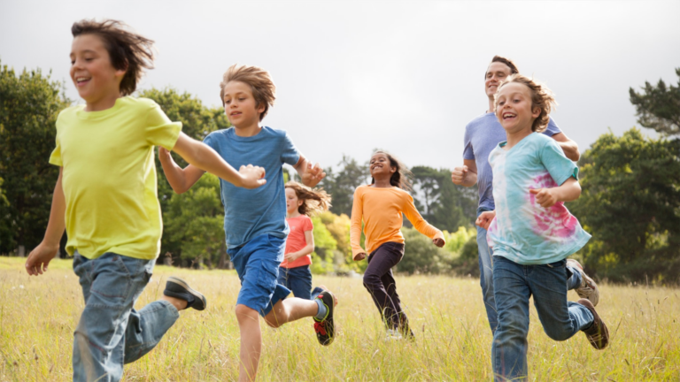 A group of children running in a field.