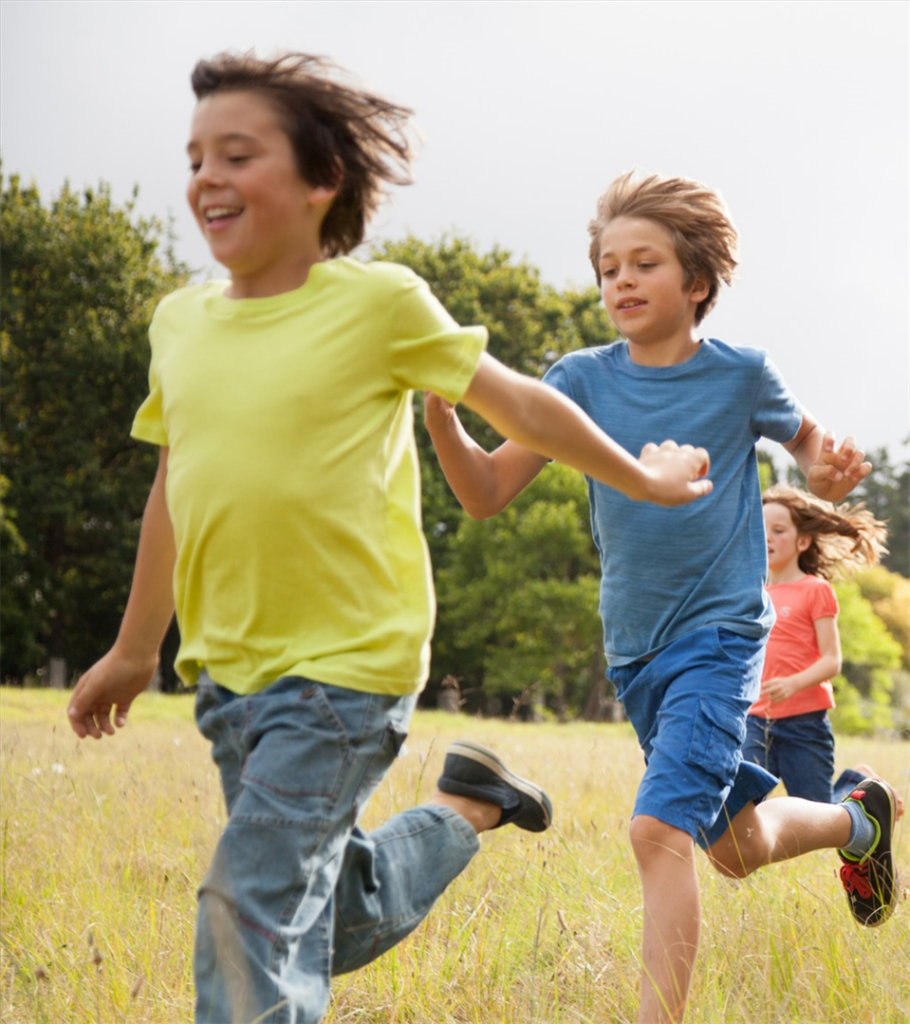 A group of kids running in a field.