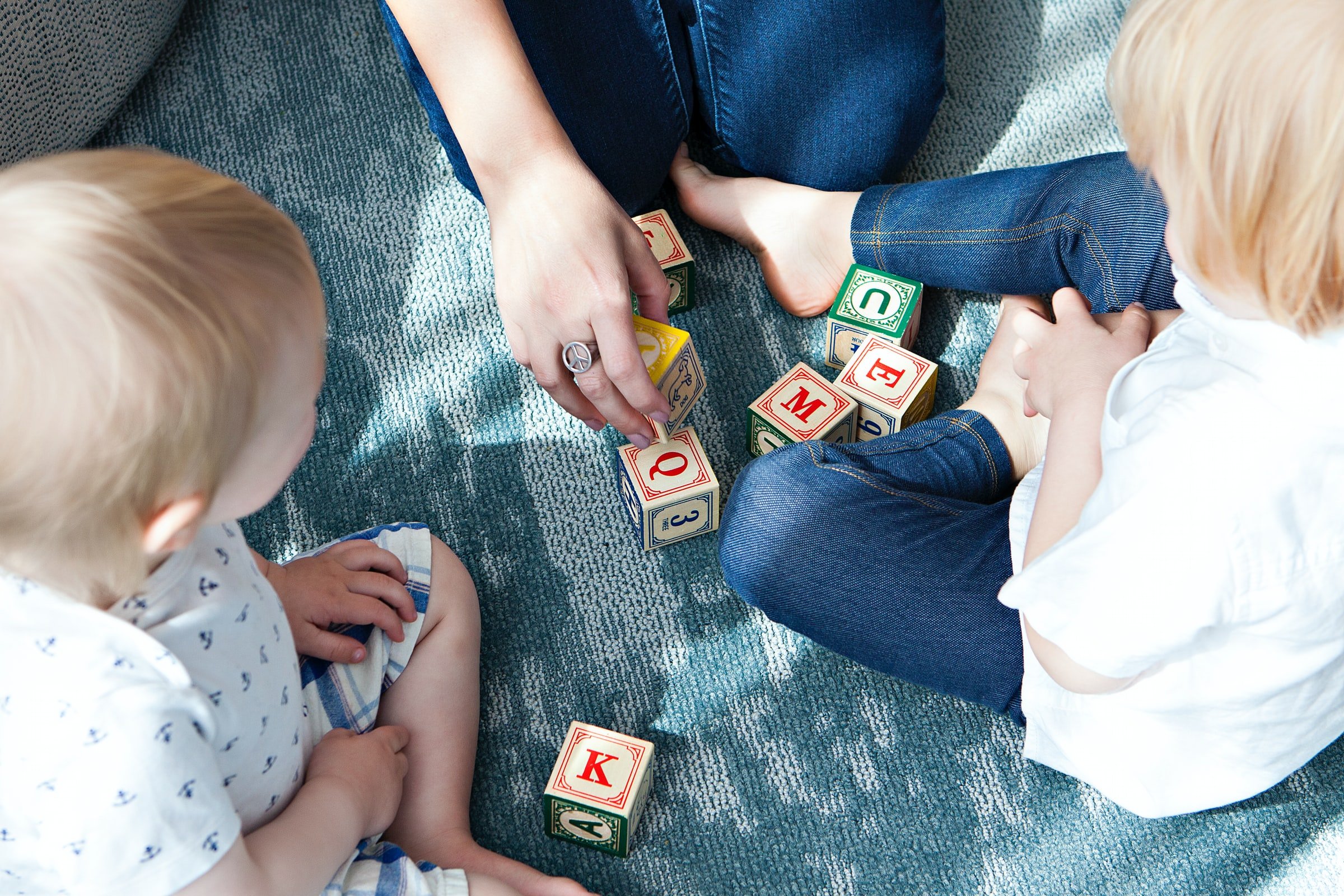 Two children achieving communication milestones while playing with wooden blocks.