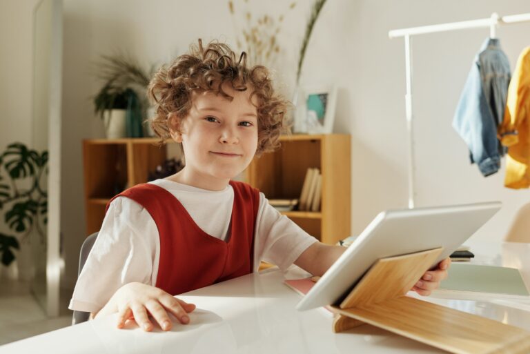 A young boy utilizing a Proloquo AAC program on a tablet computer.