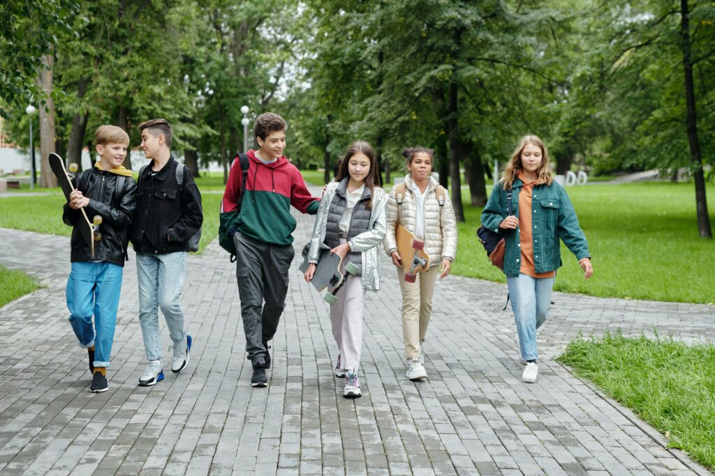 A group of young people participating in a program while walking in a park.