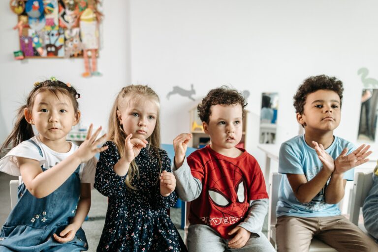 A group of children participating in the Key Word Sign Program in a classroom.
