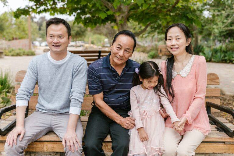 A family sitting on a bench in a park, highlighting autism awareness.